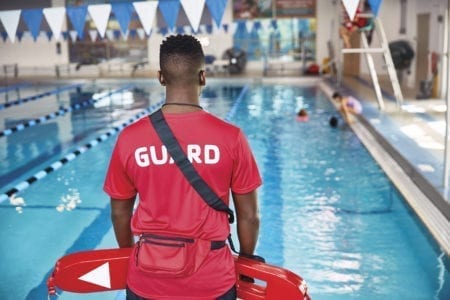 Lifeguard standing by pool.