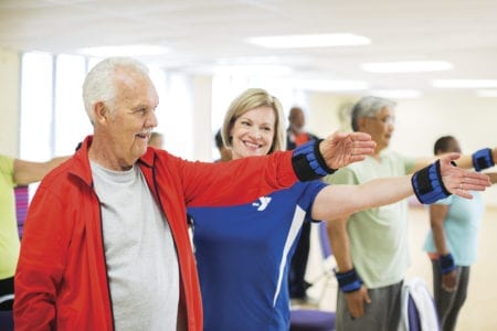 A person leading a group of people in a dance class.