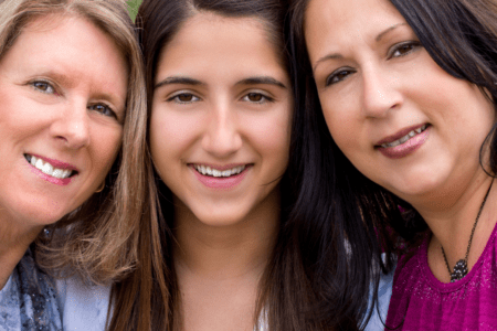Three women smiling at camera.