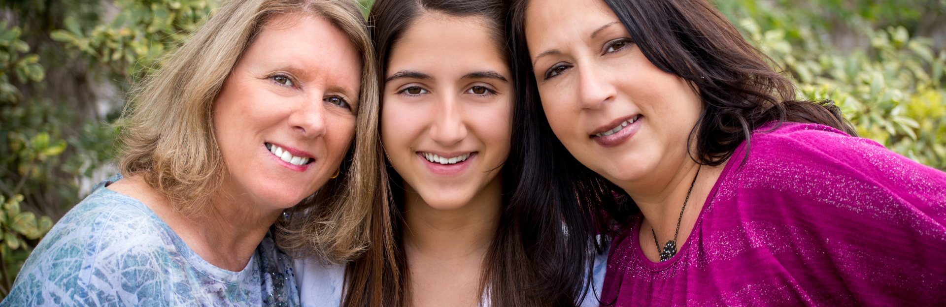 Three women smiling at camera.