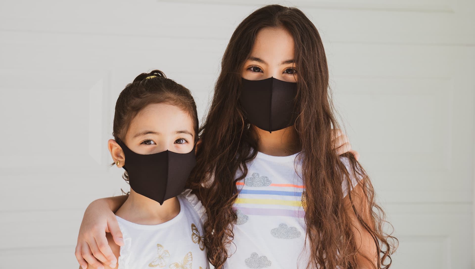 Two girls wearing black masks