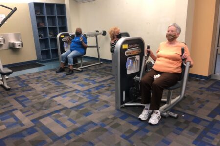 Three seniors exercising in gym