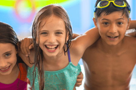 Five smiling children at pool
