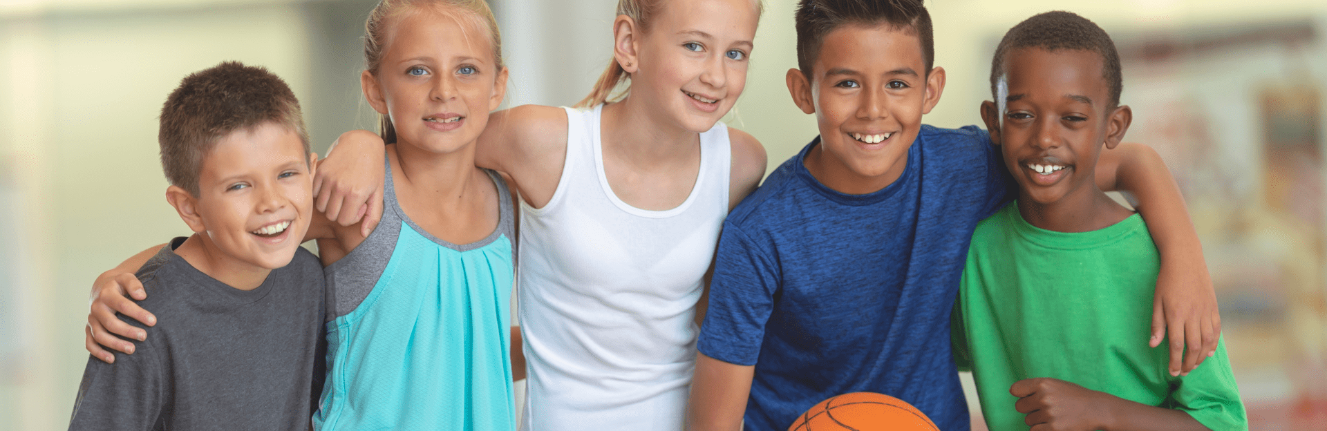 Five children smiling together with basketball