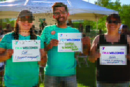 Three people holding signs at event.