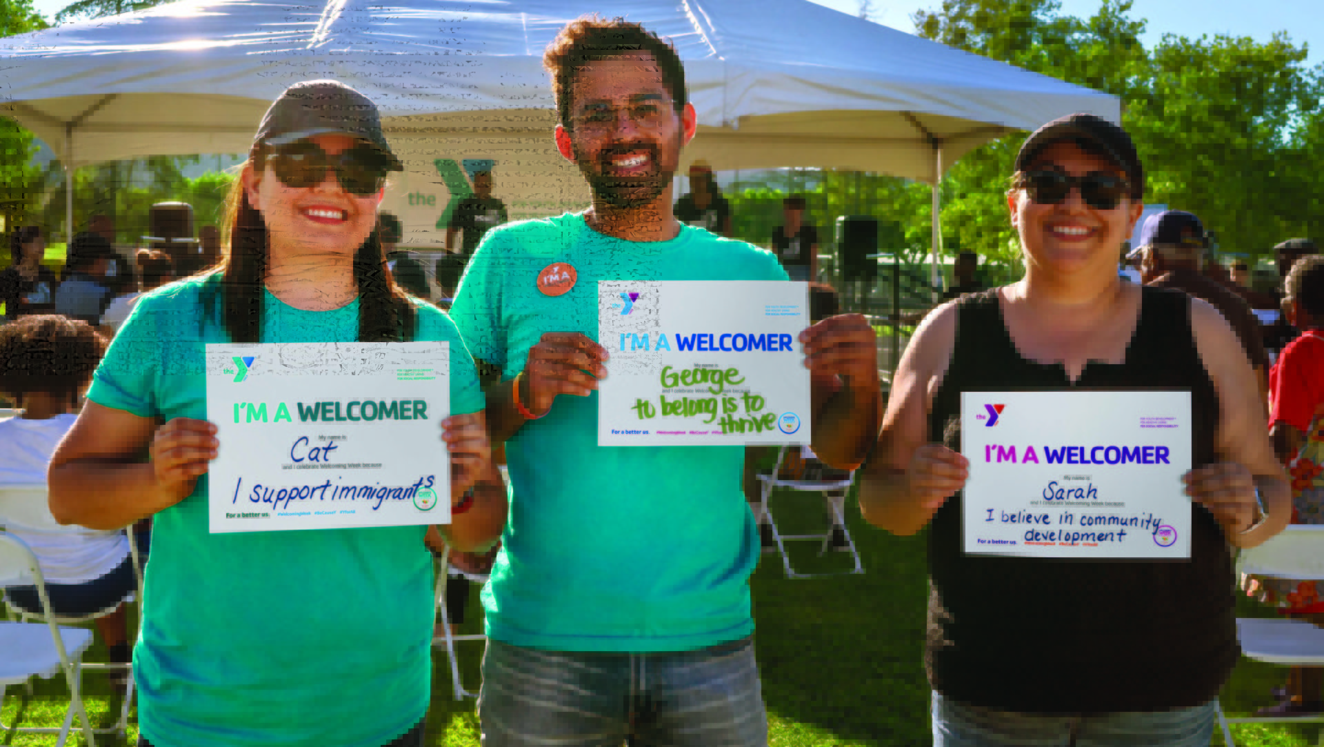 Three people holding signs at event.